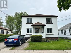 Welland (Lincoln/Crowland) multi-family for rent - A blue car is parked in front of a white house with a brown roof.