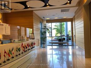 Toronto (Bendale) condo for rent - A reception area with a white counter and a row of small flags.
