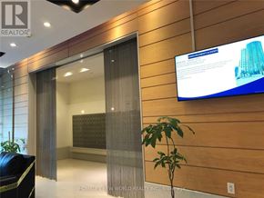 Toronto (Bendale) condo for rent - A modern office lobby with a glass door and a television screen displaying an advertisement.