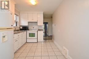 Toronto (Clairlea-Birchmount) apartment for rent - A white kitchen with a refrigerator, microwave, oven, and cabinets.