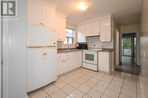Toronto (Clairlea-Birchmount) apartment for rent - A white kitchen with a refrigerator, oven, and microwave.