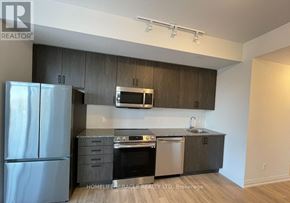 Toronto (Woburn) condo for rent - A kitchen with a refrigerator, microwave, oven, and sink.