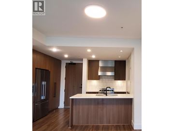 Richmond apartment for rent - A modern kitchen with dark wood cabinets and a white countertop.