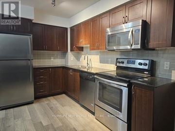 Richmond Hill (Doncrest) condo for rent - A kitchen with wooden cabinets and a black stove top.