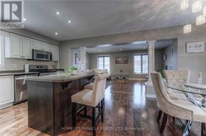 Guelph (Pineridge/Westminster Woods) apartment for rent - A modern kitchen with a bar area and a dining table.