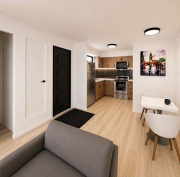 Albuquerque apartment for rent - A modern living room with a grey couch and a kitchen area in the background.