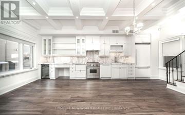 Toronto (Mount Pleasant West) townhouse for rent - A spacious kitchen with white cabinets and a wooden floor.