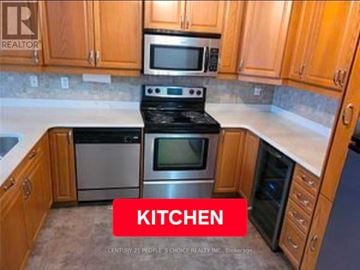 London East (East F) condo for rent - A kitchen with wooden cabinets and a stove top oven.