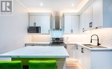 Hamilton (Industrial Sector) apartment for rent - A modern kitchen with white cabinets and a marble table.