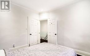 Hamilton (Industrial Sector) apartment for rent - A bedroom with a bed, two doors, and a window.