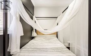 Hamilton (Industrial Sector) apartment for rent - A bedroom with a bed covered in white bedding and white curtains.