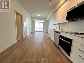 Vaughan (Concord) condo for rent - A spacious kitchen with wooden floors and white cabinets.