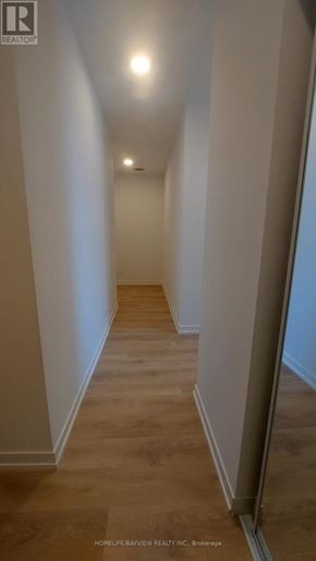 Vaughan (Beverley Glen) condo for rent - A long hallway with wooden floors and white walls.