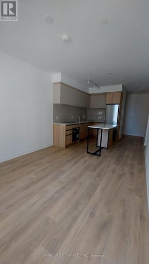 Vaughan (Beverley Glen) condo for rent - A room with wooden flooring and a kitchenette.