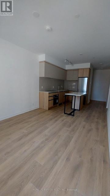 Vaughan (Beverley Glen) condo for rent - A room with wooden flooring and a kitchenette.