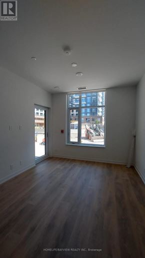 Vaughan (Beverley Glen) condo for rent - A room with wooden floors and a large window overlooking a street.
