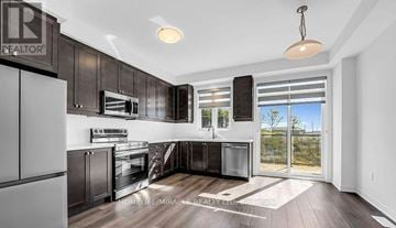 Brant (Paris) townhouse for rent - A modern kitchen with dark wood cabinets and stainless steel appliances.