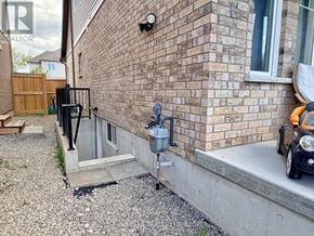 Niagara Falls (Lyons Creek) apartment for rent - A brick house with a black gate and a car parked in front.