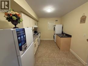 Burnaby apartment for rent - A kitchen with a fridge that has a sign on it.