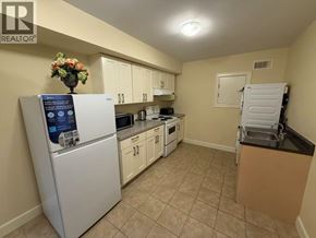 Burnaby apartment for rent - A kitchen with a white fridge and a vase of flowers on top of it.