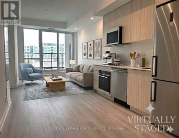 Toronto (Clairlea-Birchmount) condo for rent - A modern kitchen and living room with a blue chair and a coffee table.