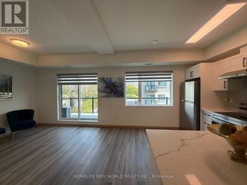 Toronto (L'amoreaux) townhouse for rent - A spacious living room with a blue sofa and a kitchen area with a sink and stove.