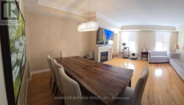 Markham (Cathedraltown) townhouse for rent - A real estate listing photo of a well-lit, spacious living room with a dining table and chairs.