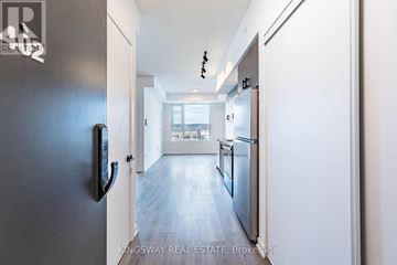 Burlington (Alton) condo for rent - A modern kitchen with a refrigerator on the left and a view of the outside through the window.