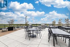 Burlington (Alton) condo for rent - A patio with tables and chairs is set up on a rooftop.