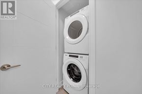 Toronto (University) condo for rent - A white washing machine in a small laundry room.