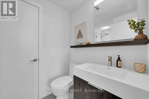 Toronto (University) condo for rent - A white bathroom with a toilet, sink, and mirror.