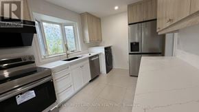 Richmond Hill (Crosby) apartment for rent - A kitchen with white cabinets and a black stove top oven.