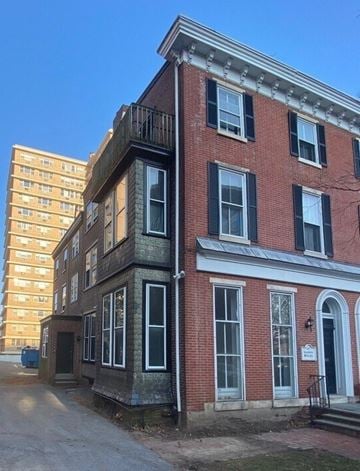 Wilmington apartment for rent - A red brick building with black shutters and a white door.