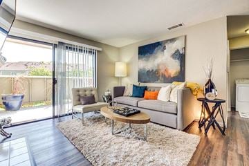 Pittsburg apartment for rent - A modern living room with a grey sofa, a coffee table, and a painting on the wall.