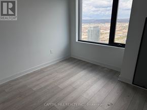 Vaughan (Vaughan Corporate Centre) condo for rent - A room with a large window overlooking a cityscape.