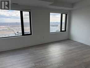 Vaughan (Vaughan Corporate Centre) condo for rent - A large empty room with a view of the city through the windows.