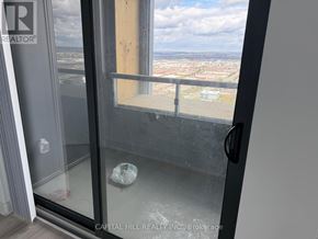 Vaughan (Vaughan Corporate Centre) condo for rent - A glass door with a handle and a window with a view of the city.