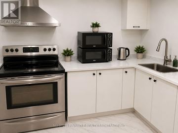 London South (South U) apartment for rent - A modern kitchen with a stainless steel stove, black microwave, and white cabinets.