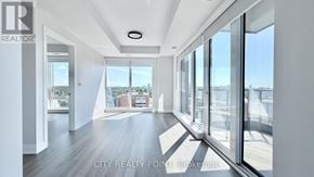 Toronto (Forest Hill North) condo for rent - A spacious room with a view of the cityscape through large windows.