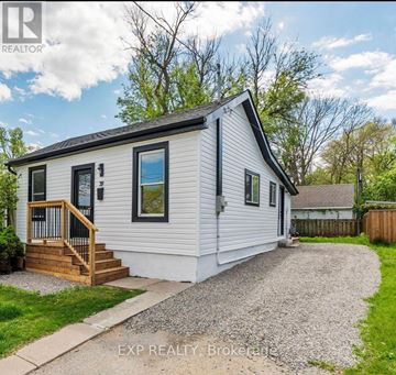 London East (East K) apartment for rent - A small white house with a wooden deck and a gravel driveway.