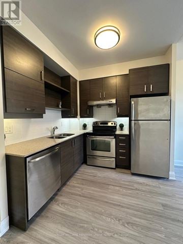 Markham (Unionville) condo for rent - A modern kitchen with stainless steel appliances and wooden cabinets.