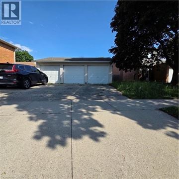 Kitchener apartment for rent - A black car is parked in front of a garage.