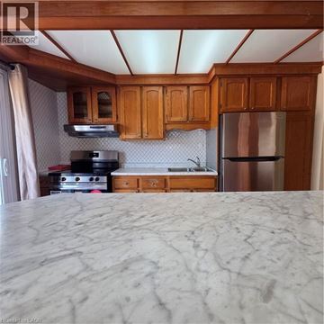 Kitchener apartment for rent - A kitchen with wooden cabinets and a marble countertop.