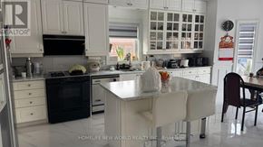 Markham (Milliken Mills East) apartment for rent - A kitchen with white cabinets and a black oven.