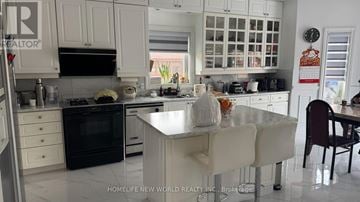 Markham (Milliken Mills East) apartment for rent - A kitchen with white cabinets and a black oven.