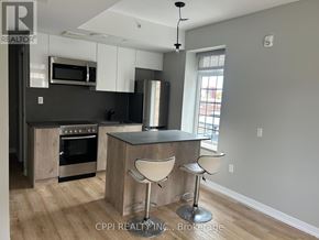 Oshawa (Central) condo for rent - A modern kitchen with a bar stool.