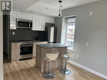 Oshawa (Central) condo for rent - A modern kitchen with a bar stool.