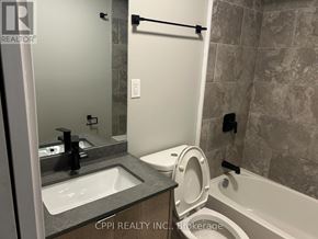Oshawa (Central) condo for rent - A bathroom with a toilet, sink, and bathtub.