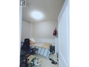 Vancouver apartment for rent - A small bedroom with a bed, a desk, and a chair.