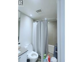 Vancouver apartment for rent - A white toilet in a small bathroom with a shower curtain.